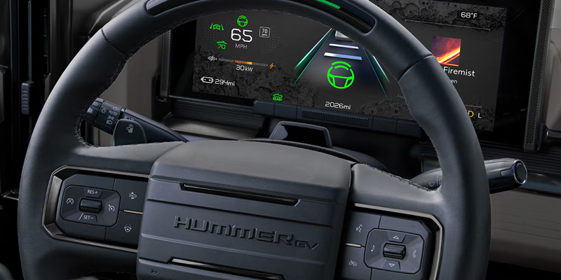 Close-up of the Hummer EV steering wheel showing digital display with speed and battery information.