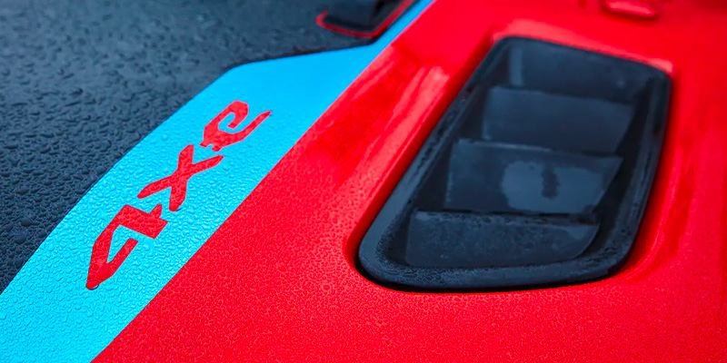 Close-up of a red surface with blue and red accents, featuring the text '4xe' and a black opening.